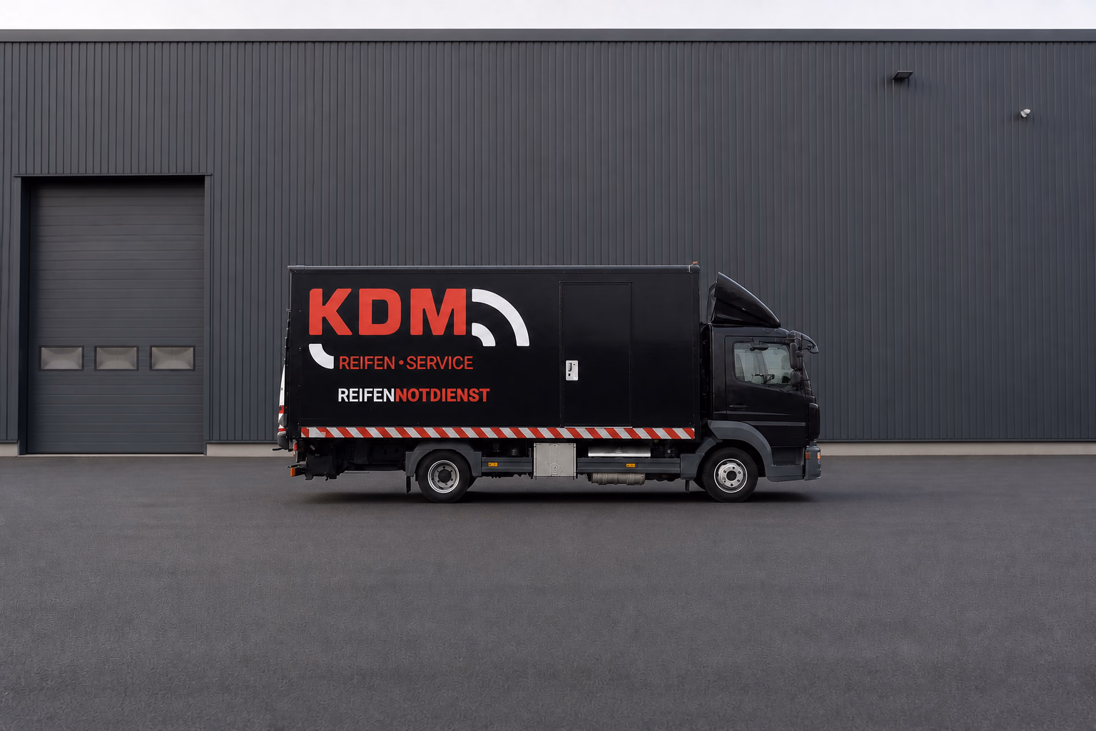 Schwarzer KDM-LKW für den Reifenpannenservice